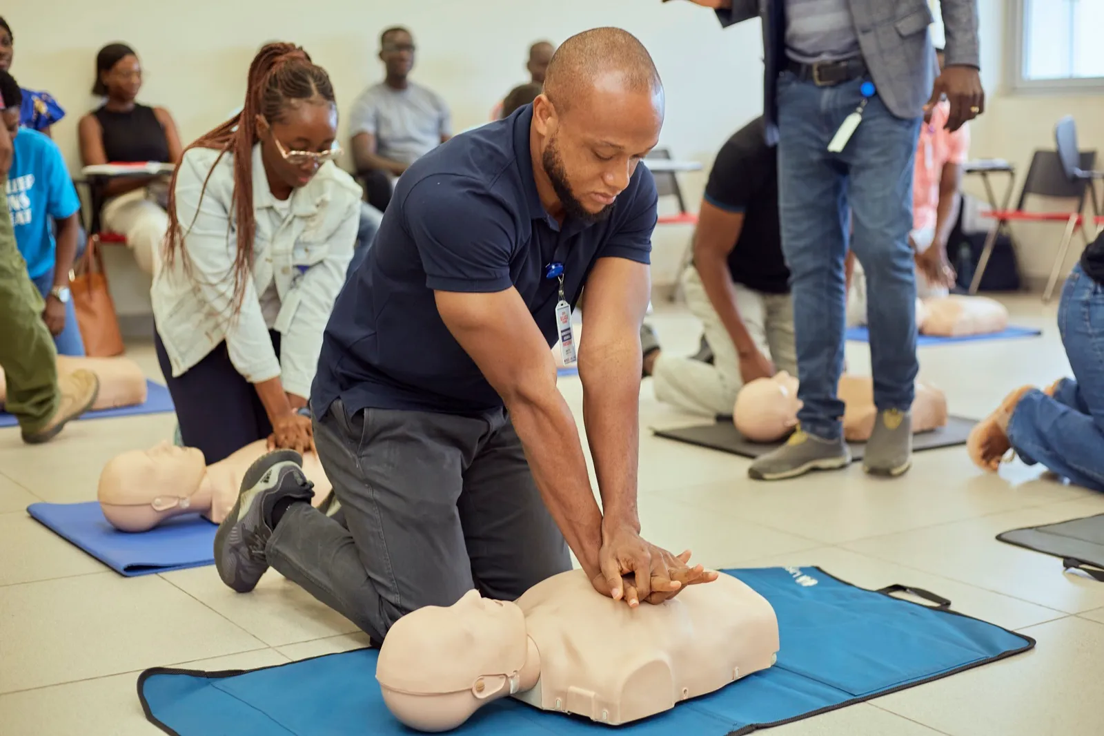 Instructor demonstrating CPR technique on a mannequin during a BLS training session